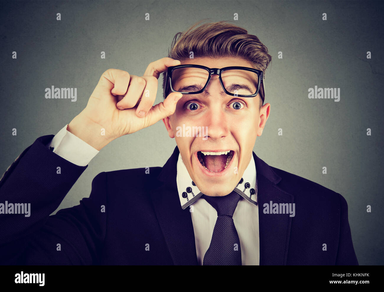 Surprised young business man taking of glasses Stock Photo Alamy