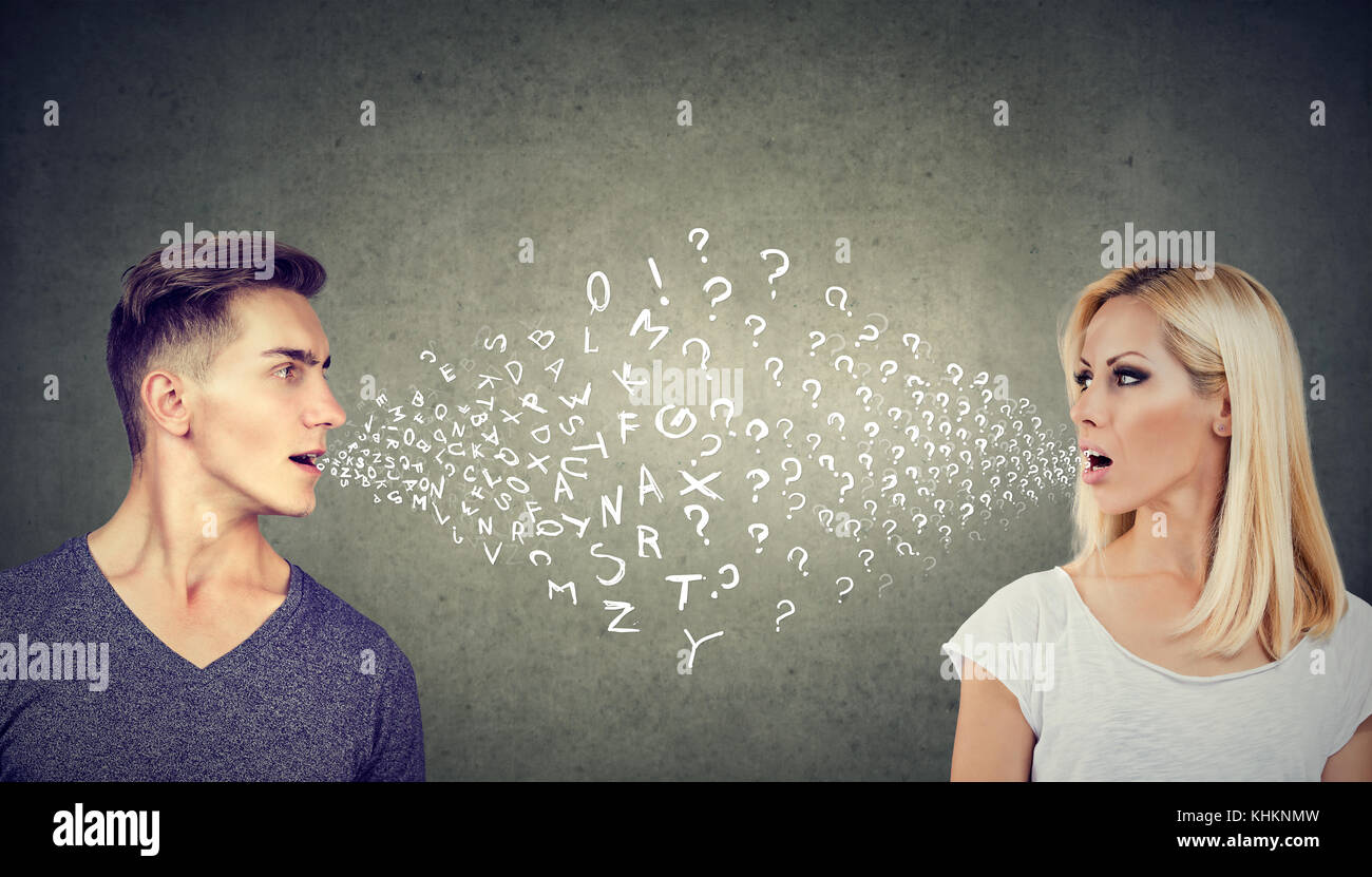 Language barrier concept. Handsome man talking to an attractive young woman with many questions Stock Photo