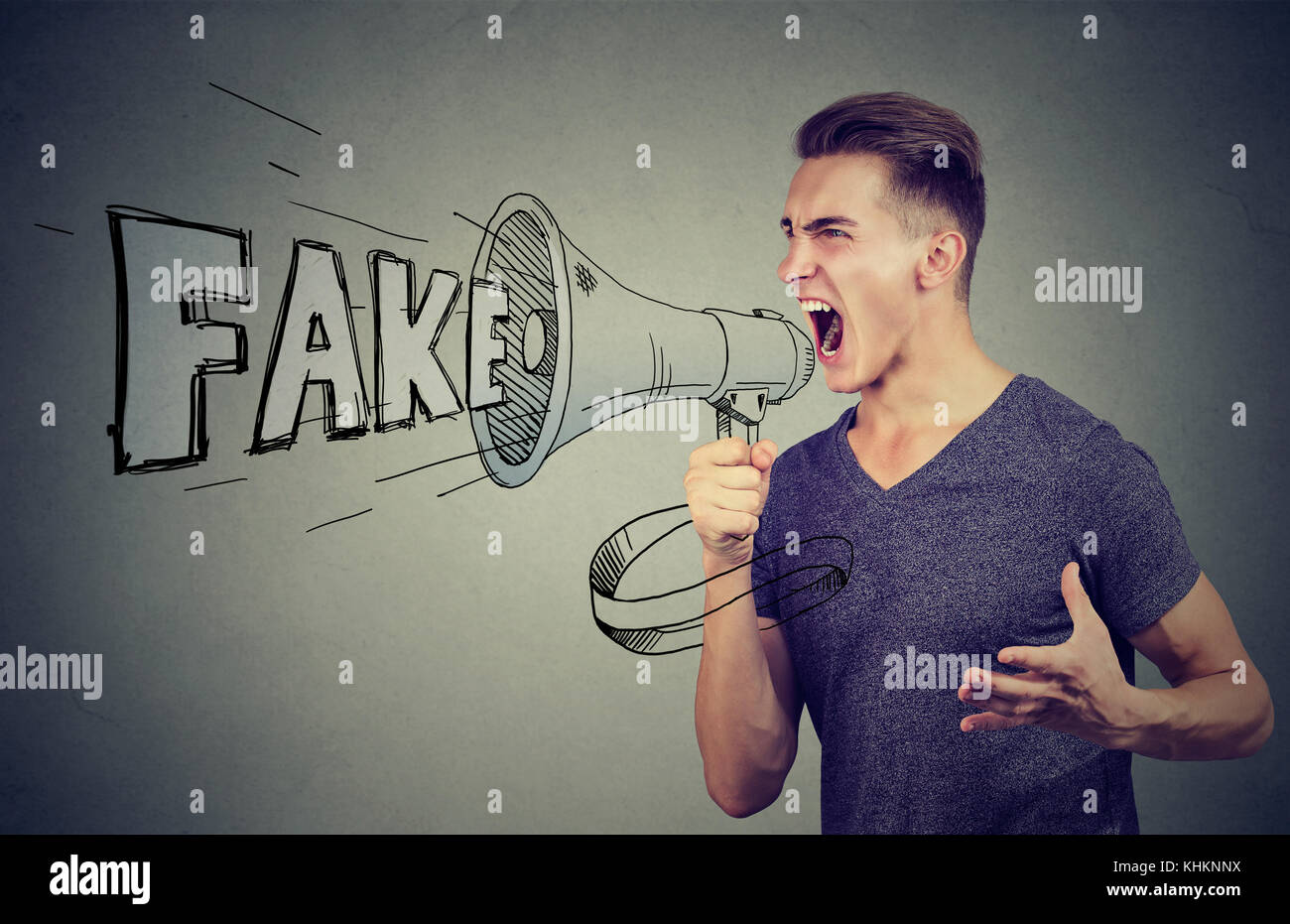 Angry enthusiastic man screaming in a megaphone spreading fake news Stock Photo