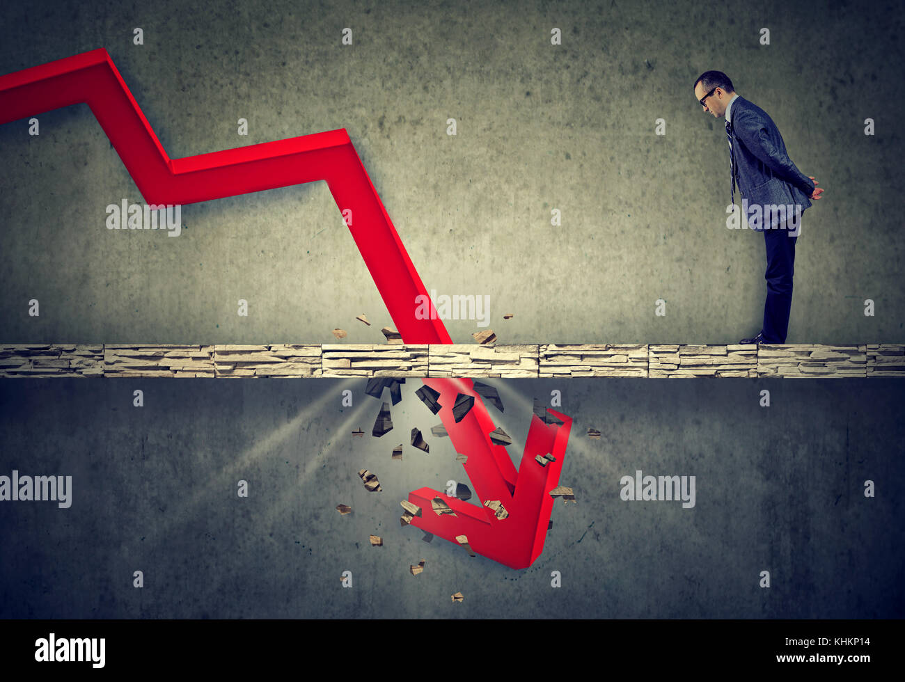 Curious worried business man looking down at the falling red arrow ...