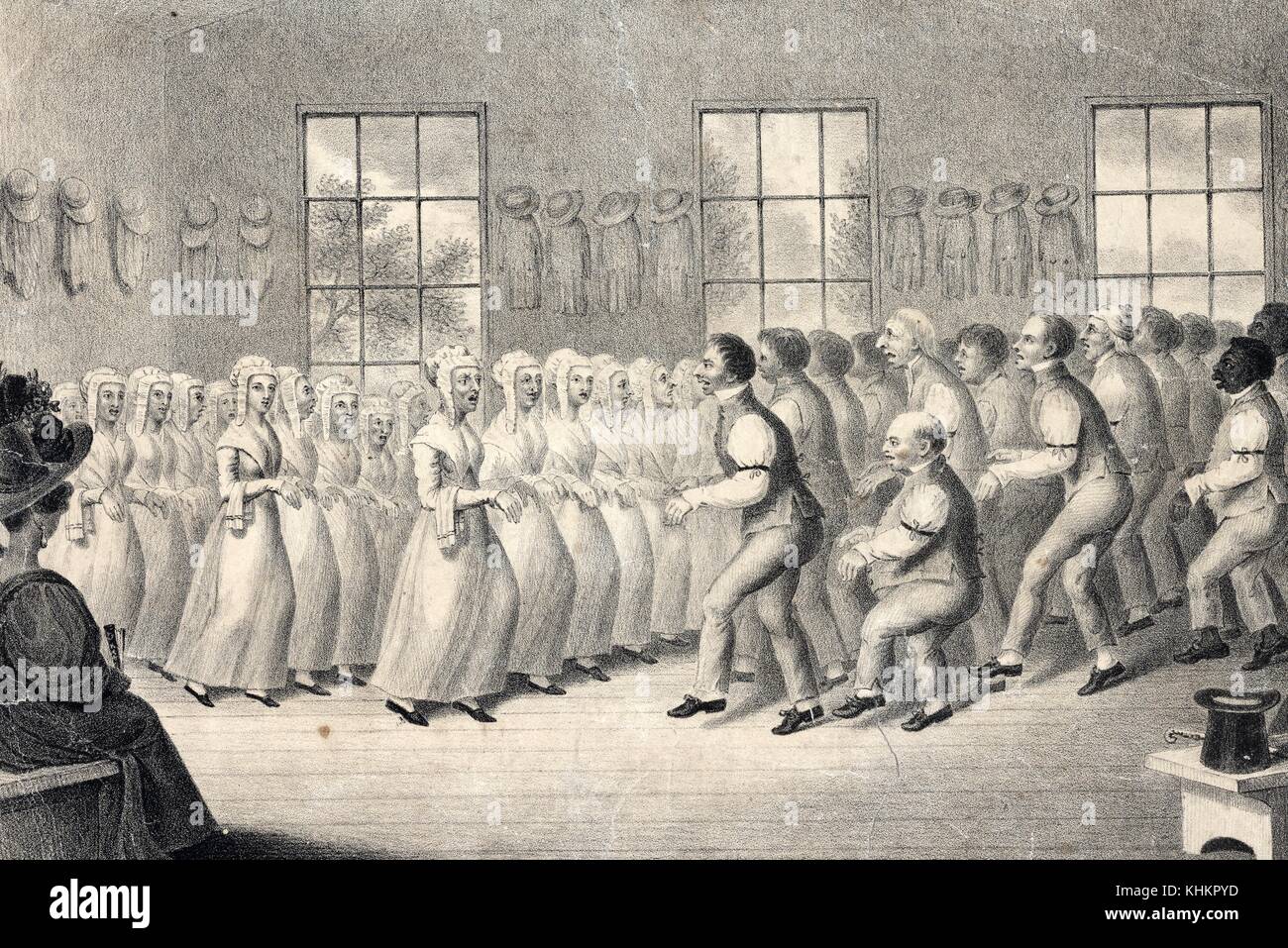 A lithograph that depicts a large group of Shakers, who are performing a ritual dance that was described as trembling, a part of their worship service, the left side of the room consists of women wearing long dresses and bonnets, the right side of the room is entirely men wearing shirts, vests and pants, each group faces the other while performing this dance, 1834. From the New York Public Library. Stock Photo