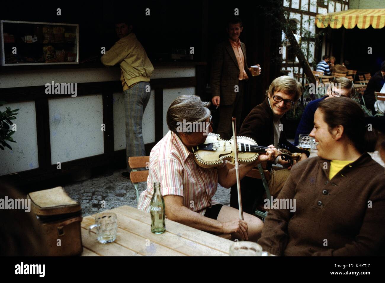 Woman playing a fiddle in a cafe, empty bottle of Coca Cola visible, Ireland, 1960. Stock Photo