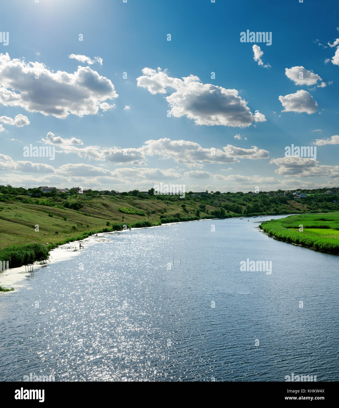 view to river with reflection under blue cloudy sky and sun Stock Photo ...