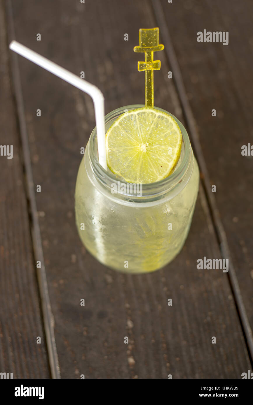 Lime juice with ice and straw in glass jar Stock Photo
