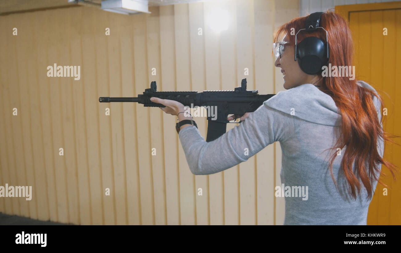Woman shooting with a Mashin gun in shooting gallery Stock Photo Alamy