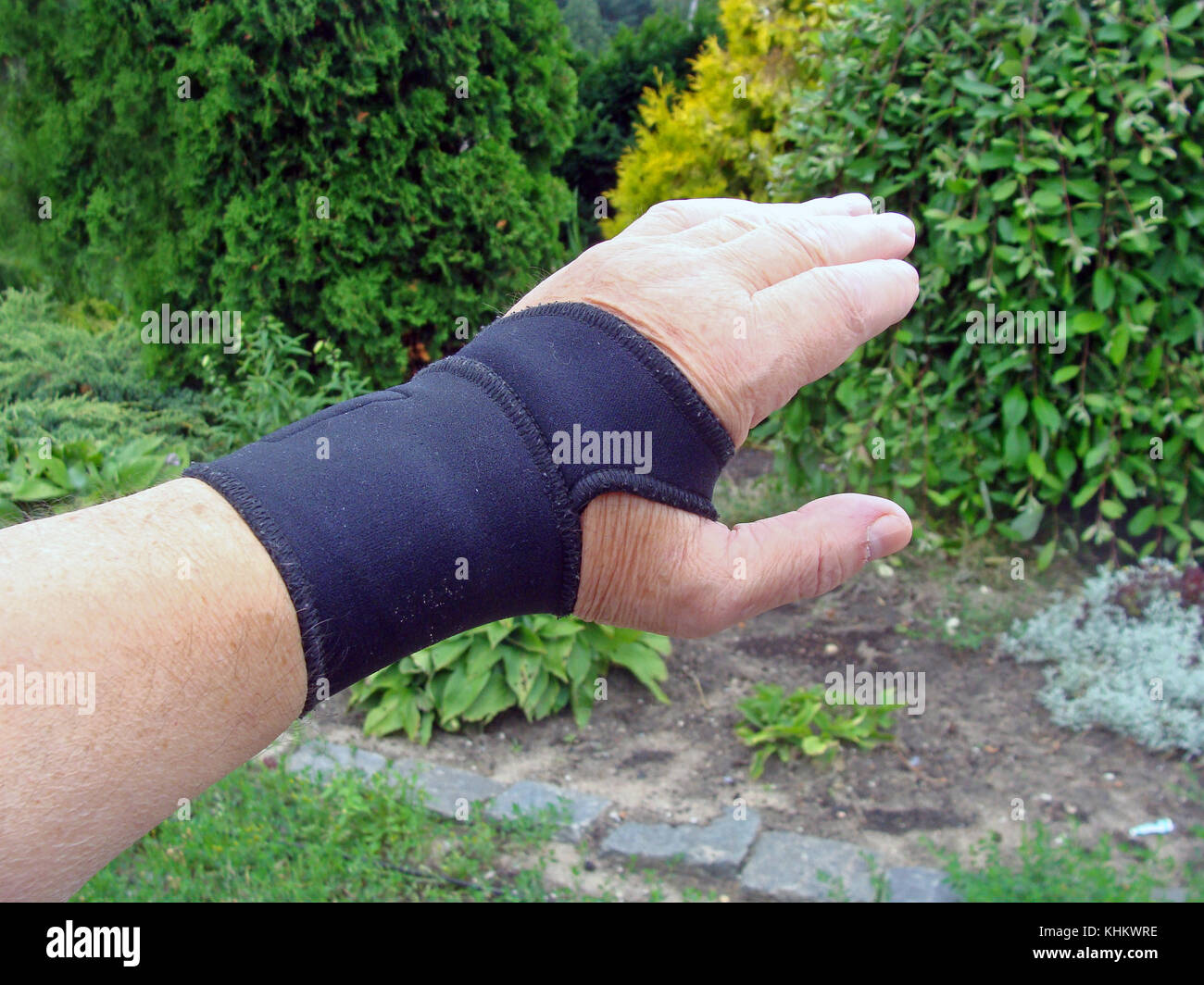 Hand with black color elastic bandage on wrist joint close up outdoor