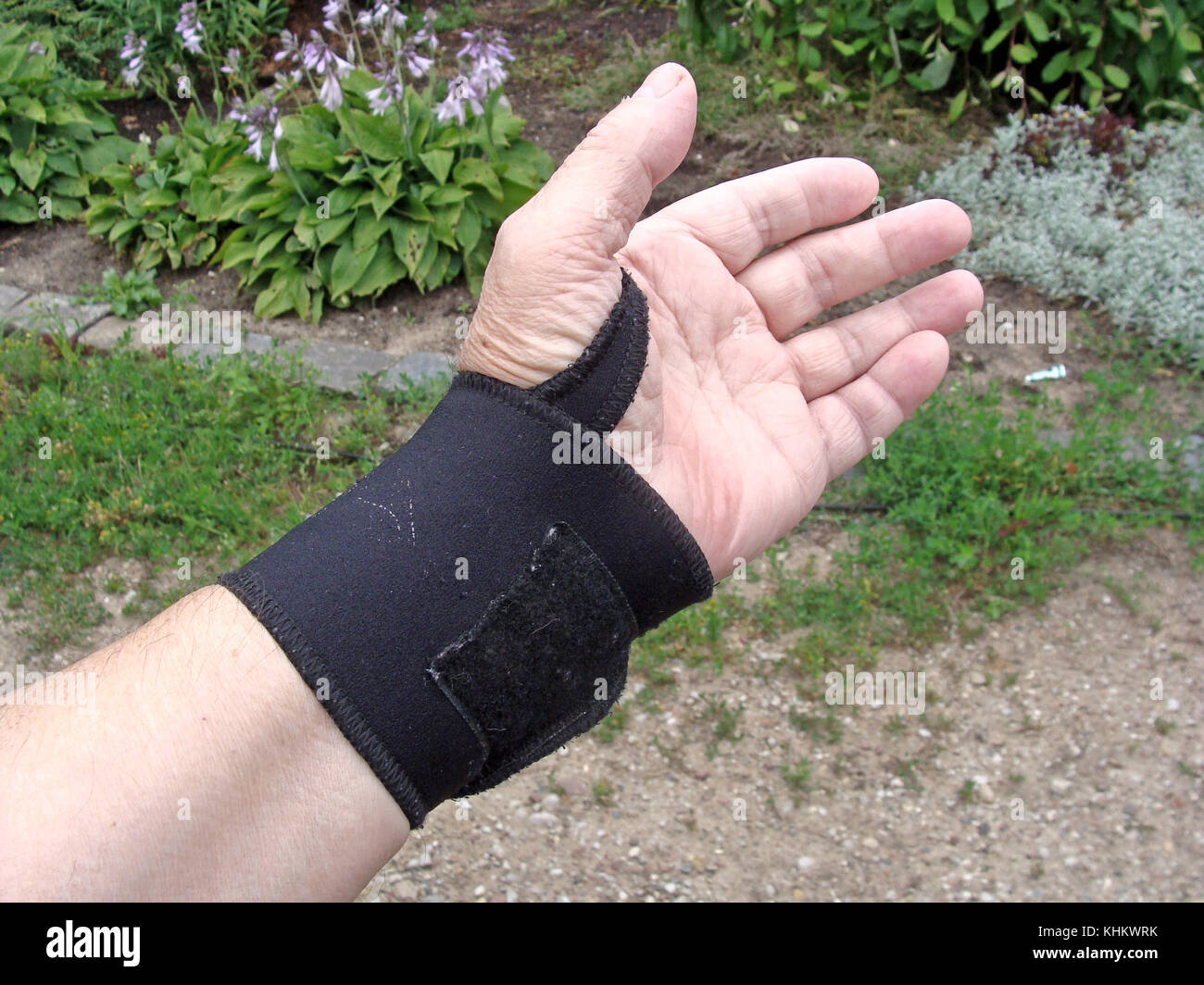 Hand with black color elastic bandage on wrist joint close up outdoor