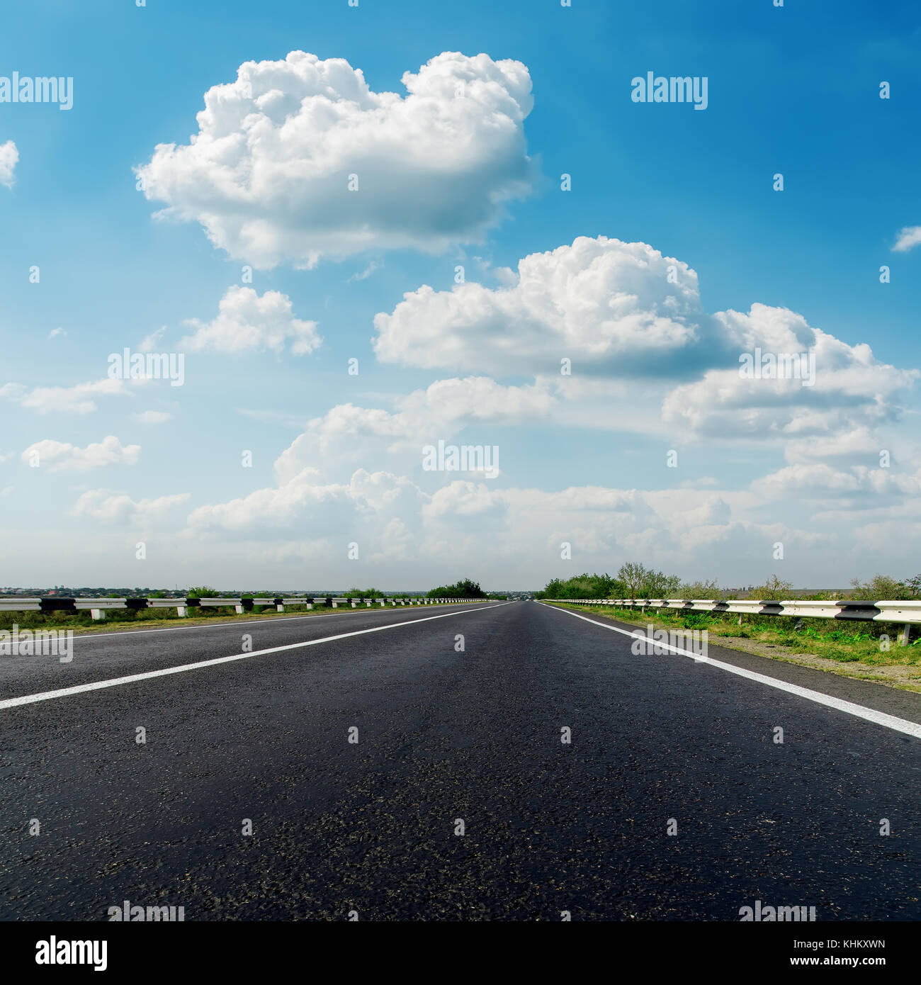 asphalt road closeup and low clouds in blue sky Stock Photo - Alamy