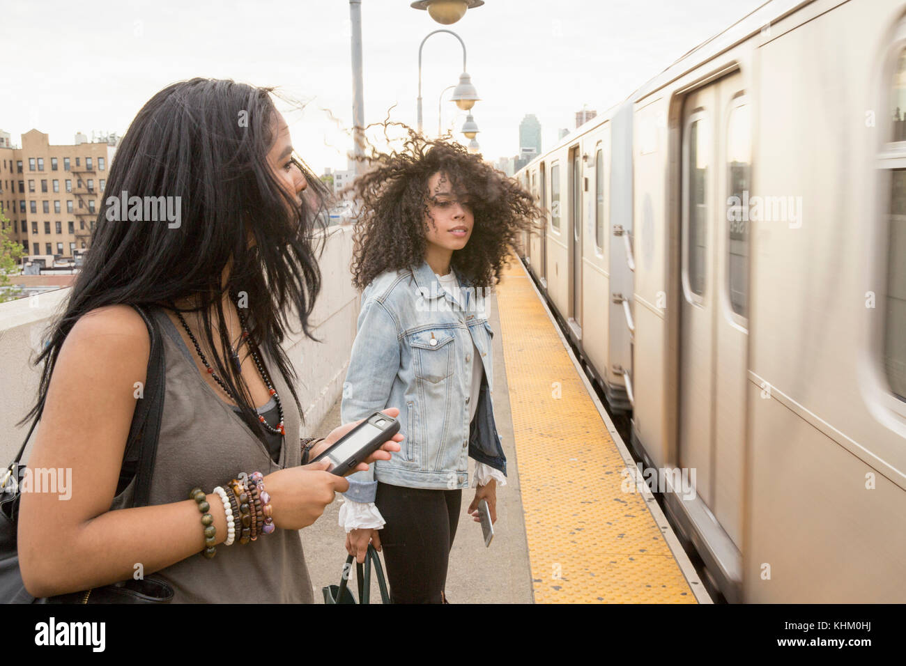 Young women waiting at a train station in Queens, New York Stock Photo
