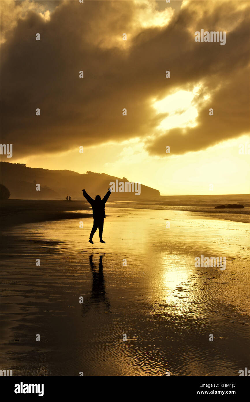 Happy Women jumping in front of the Sunset Stock Photo