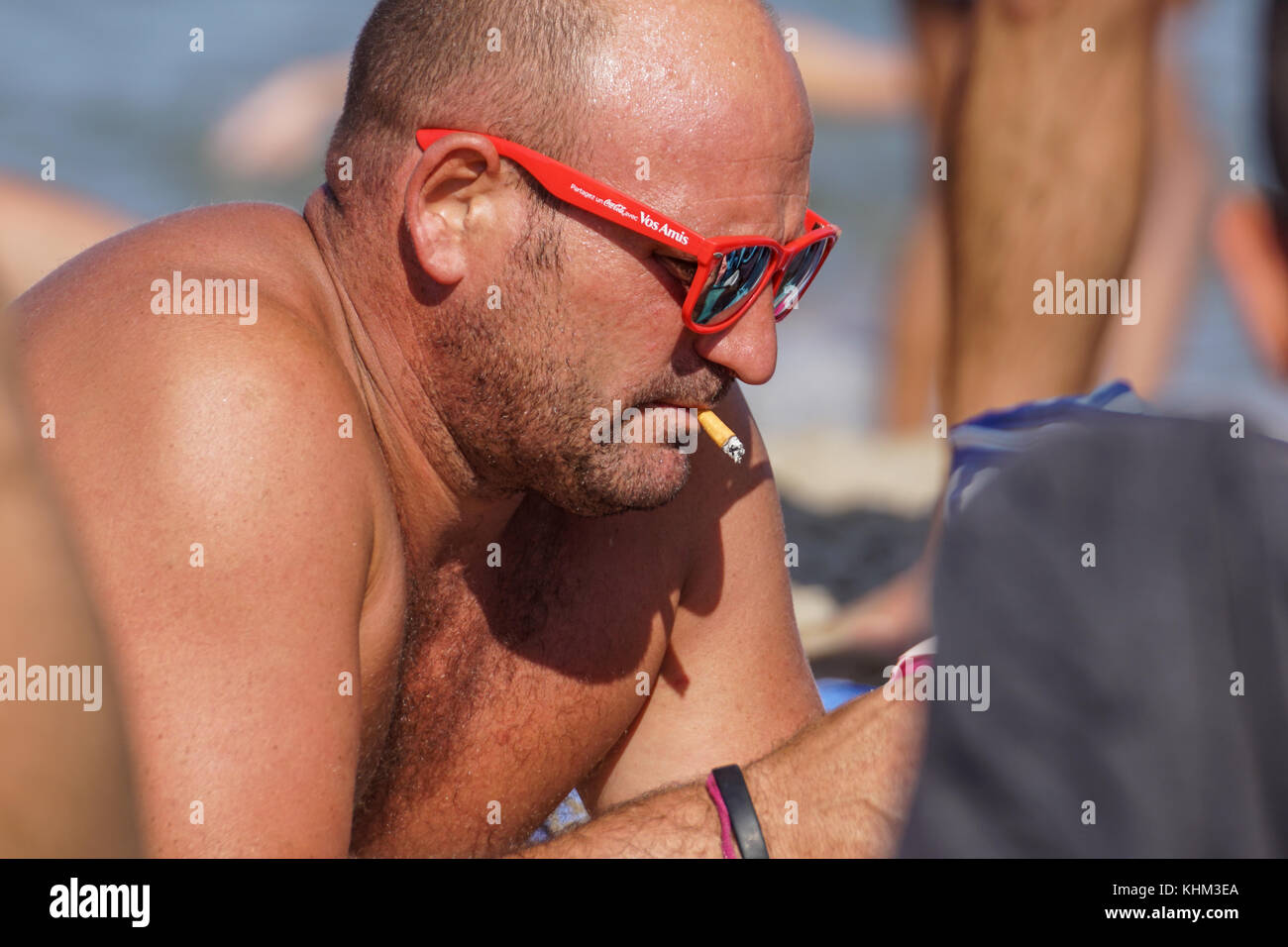 Nice , France - 5 august 2017 : Serious bearded man smoking a cigarette on the beach. Close-up portrait Stock Photo