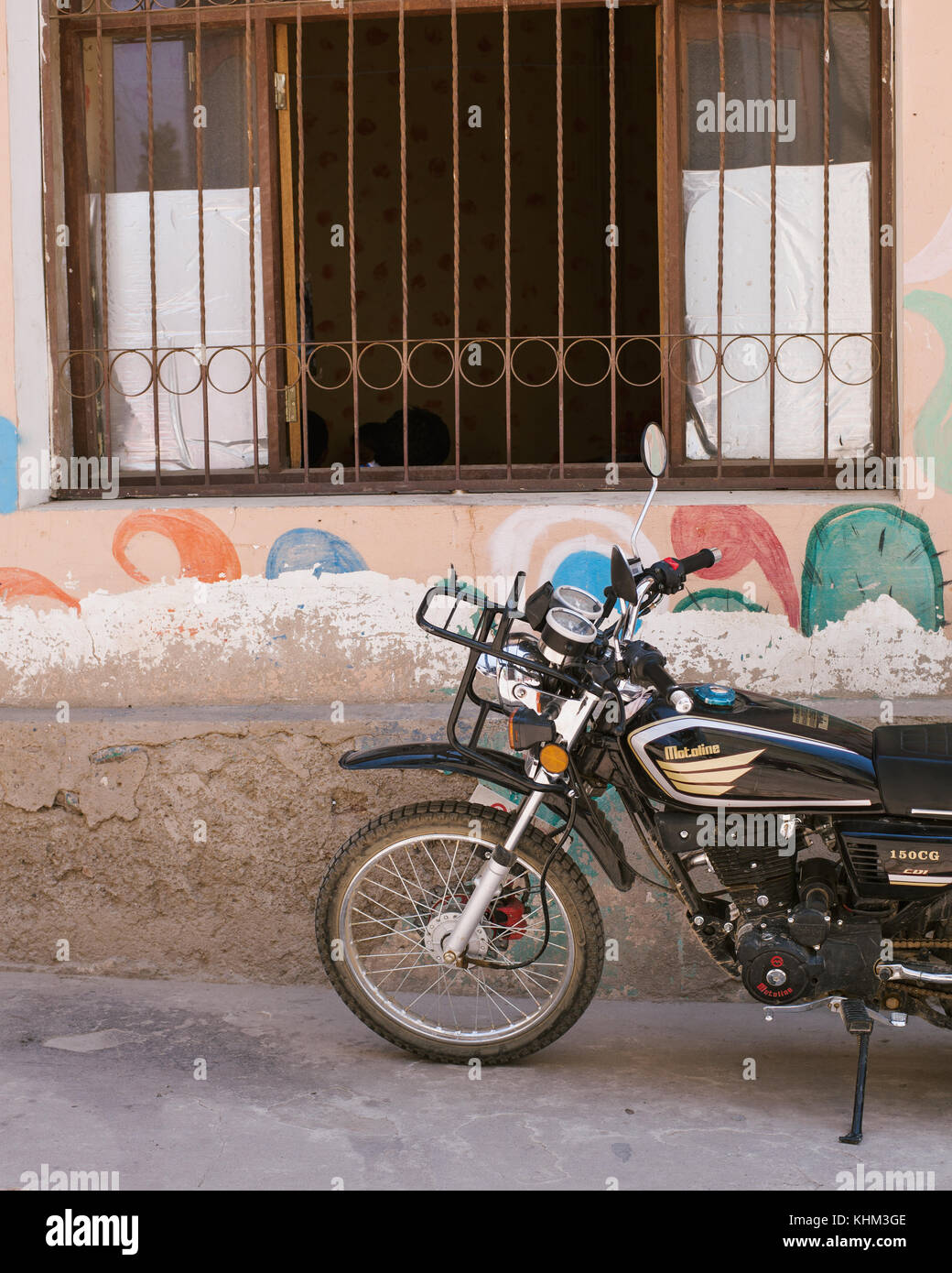 TARATA, COCHABAMBA, BOLIVIA S.A. - OCTOBER 2017: A parked Honda motorcycle along the cobblestone roads of colonial Tarata, Bolivia. Stock Photo