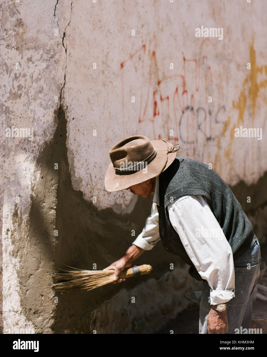 TARATA, COCHABAMBA, BOLIVIA S.A. - OCTOBER 2017: A man patches up concrete on a building in colonial Tarata, Bolivia. Stock Photo