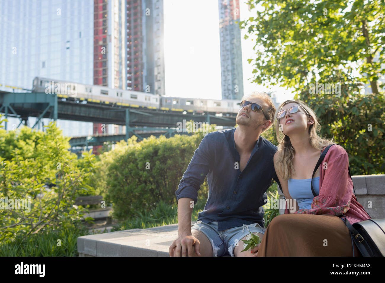 Couple sitting together in a park Stock Photo - Alamy