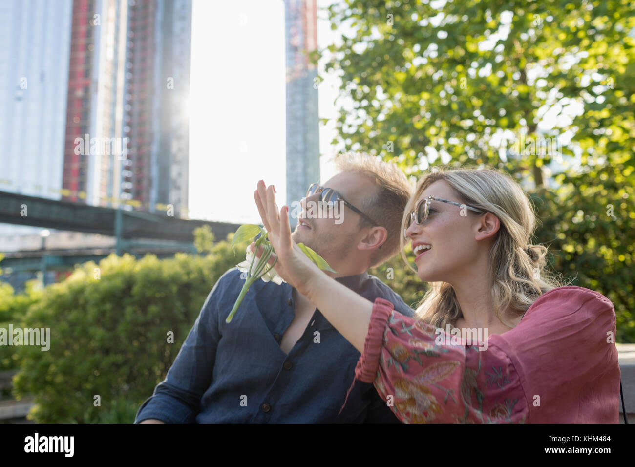 Couple sitting together in a park Stock Photo - Alamy