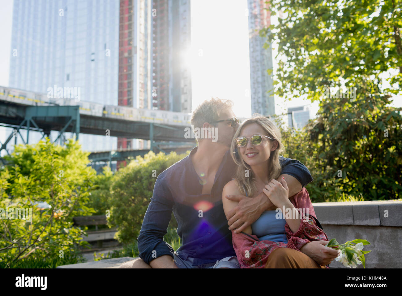 Couple sitting together in a park Stock Photo - Alamy