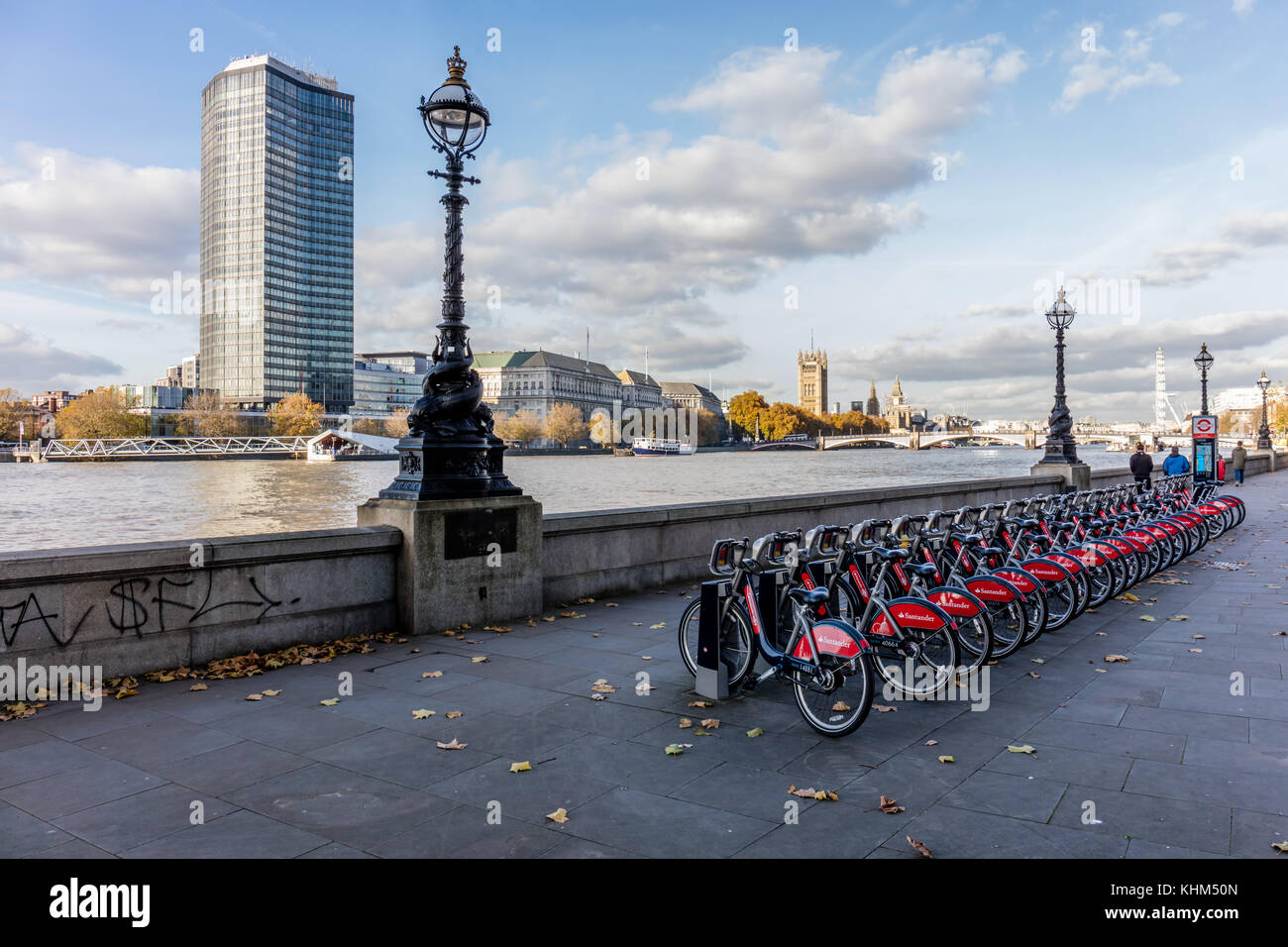 Row of 'Boris Bikes' on the Albert Embankment, Vauxhall. London.  View towards Westminster Stock Photo