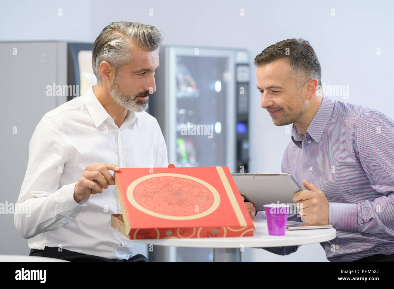 businessmen using computers in office and eat pizza Stock Photo - Alamy