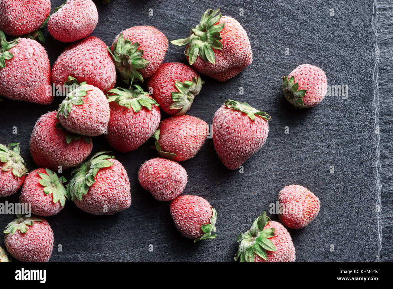 Frozen strawberry on black slate. Top view.  Close up. High resolution product. Stock Photo