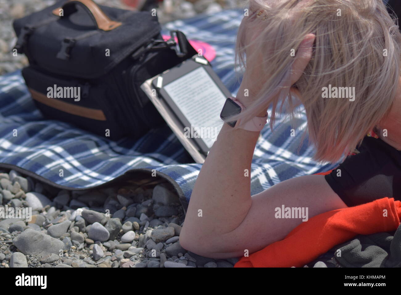 Reading Kindle on the beach Stock Photo - Alamy