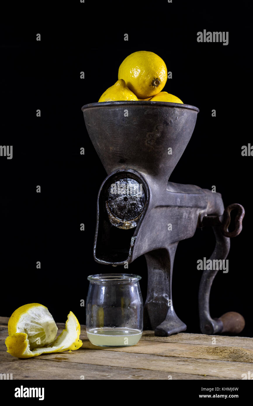 old cast iron juice machine on a wooden kitchen table. Lemon juice and