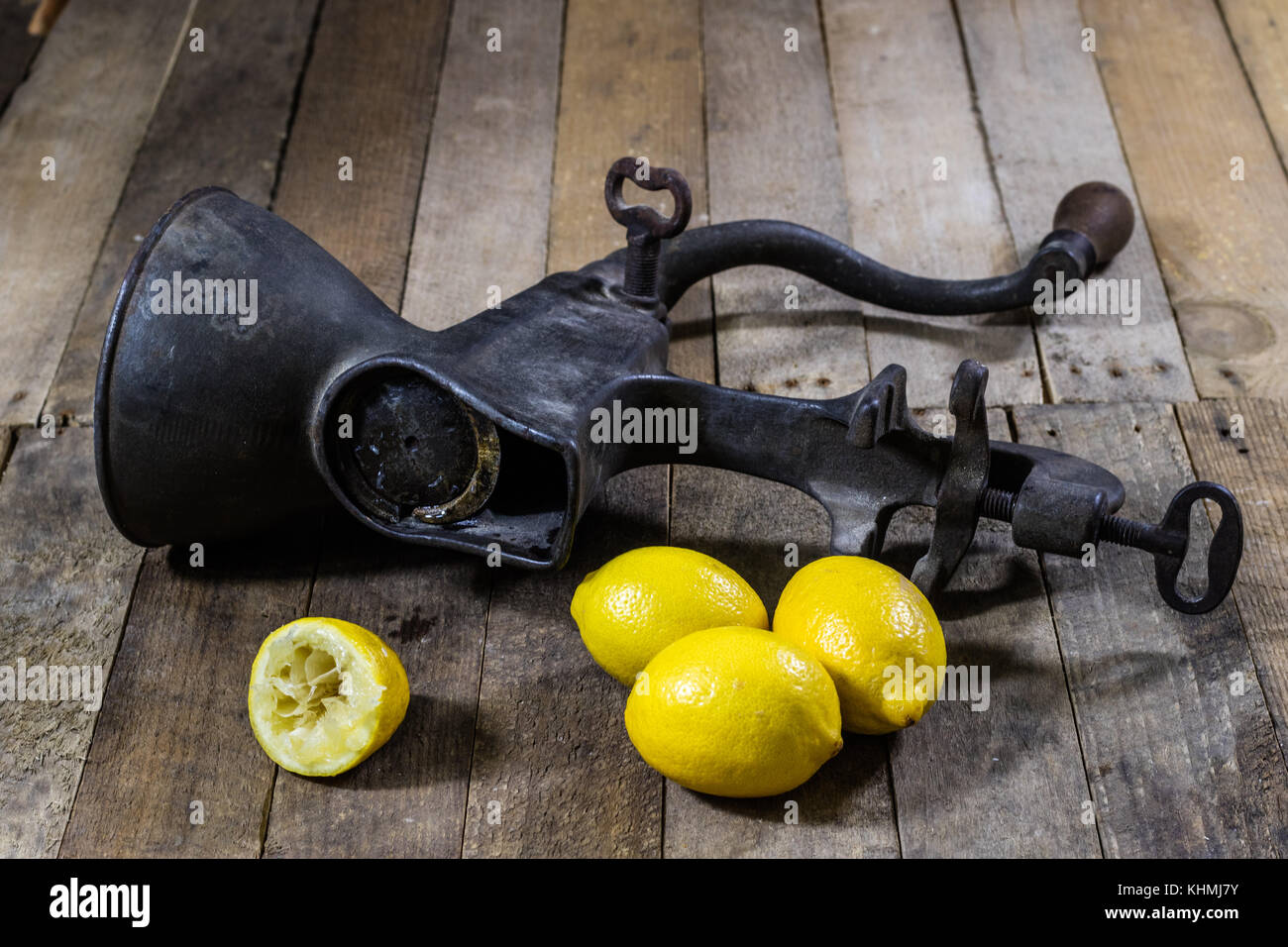 old cast iron juice machine on a wooden kitchen table. Lemon juice and