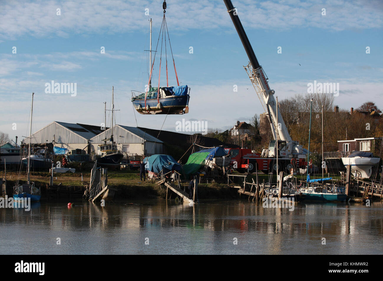 Rye, East Sussex, UK. 18th November, 2017. UK Weather: A bright and sunny start to the day, perfect for these men who with a large crane lift several boats from the River Rother into dry dock for maintenance. Rain is expected later. Photo Credit: Paul Lawrenson /Alamy Live Newsrye uk Stock Photo