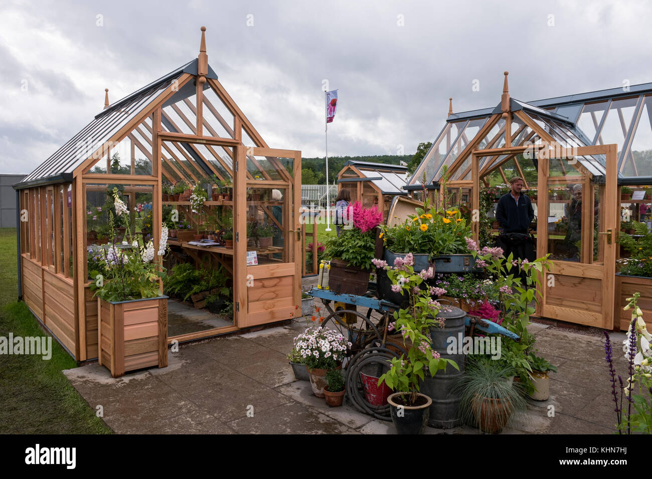 People at Gabriel Ash trade stand, viewing timber greenhouses on display & for sale RHS