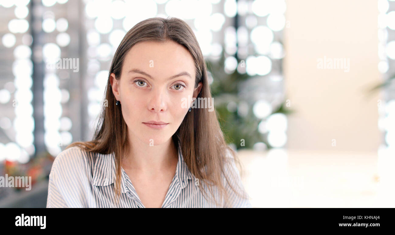 Serious woman in a public place looks at camera Stock Photo