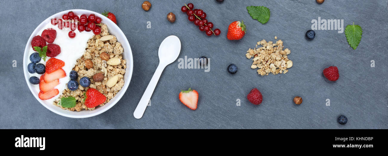 Muesli breakfast fruits yogurt strawberries cereals berries bowl slate banner top view from above Stock Photo