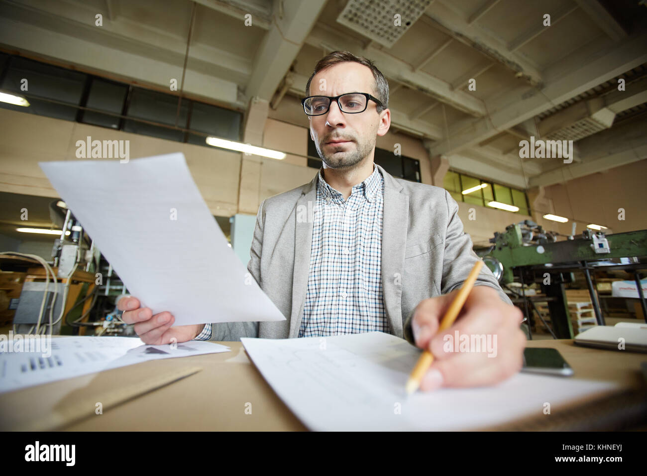 Serious man with paper making sketch of what he reading about Stock ...