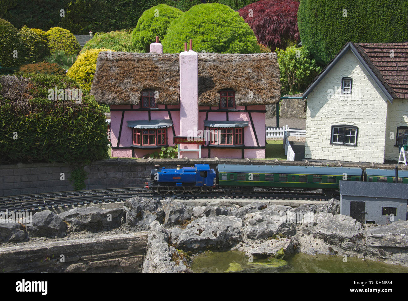 Train passing thatched roof cottage Bekonscot Model Village Beaconsfield Buckinghamshire England Stock Photo