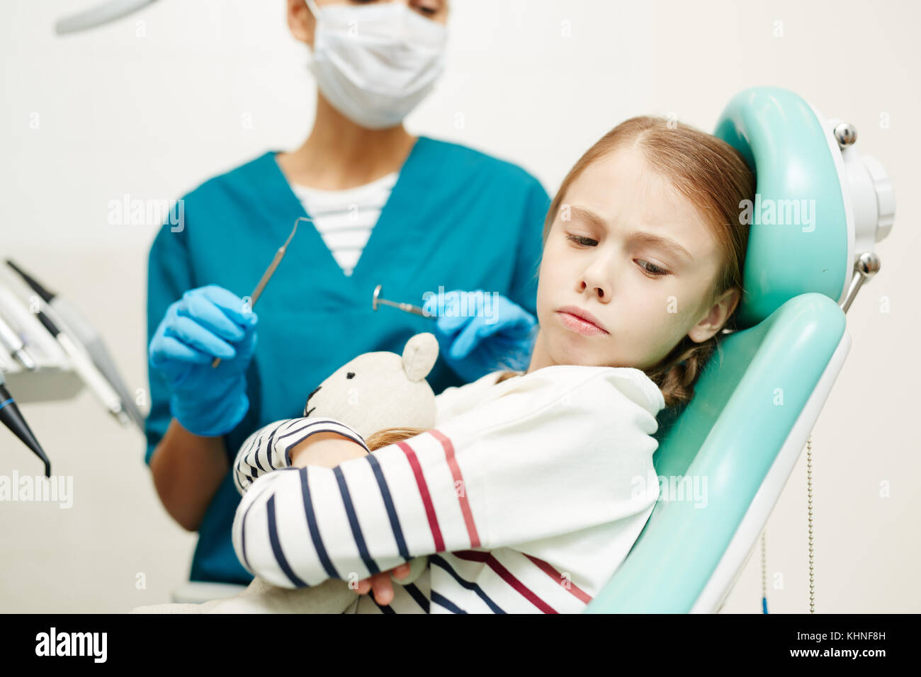 Scared Girl Turning Her Head From Dentist With Medical Tools Stock scared-girl-turning-her-head-from-dentist-with-medical-tools-stock