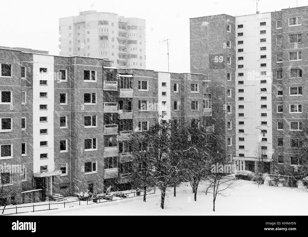 A black&white photo of a few multi-storey block flat buildings in Vilnius on a snowy day. Soviet era architecture. Stock Photo