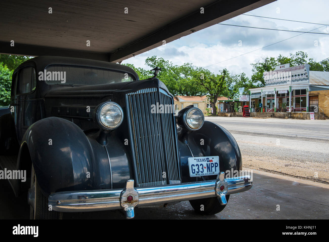 Hye, Texas - June 8, 2014: An old car with the general store and post office on the background in the small town of Hye in Texas, USA. Stock Photo