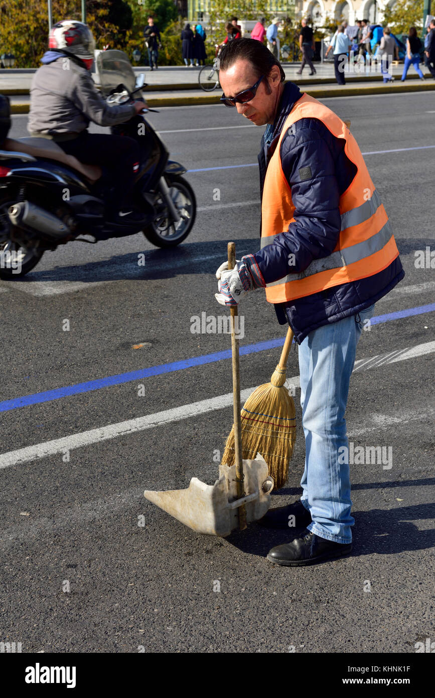 Man sweeping up litter road in city of Athens, Greece Stock Photo