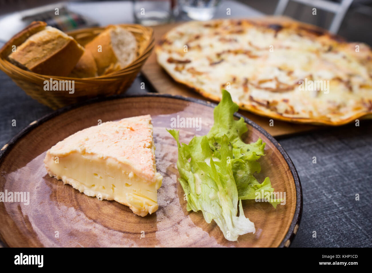 Traditional Alsace regional cheese on dinner table with Flammkuchen Stock Photo