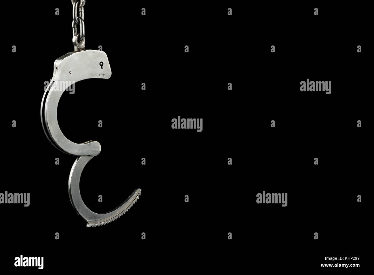 Unlocked police handcuffs on a black background with copy space Stock Photo