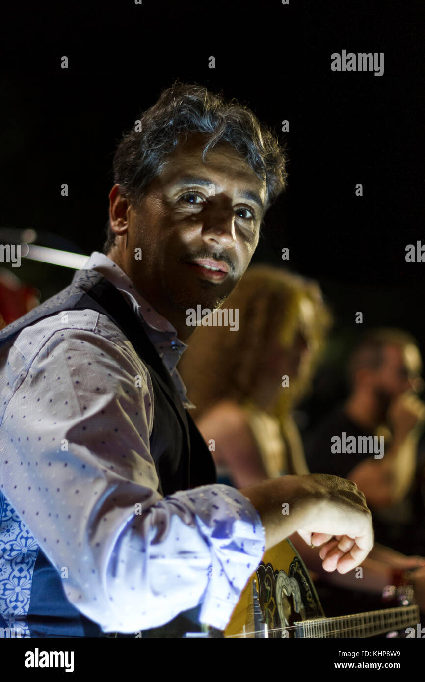 Bouzouki player resting during a live performance, in a Greek
