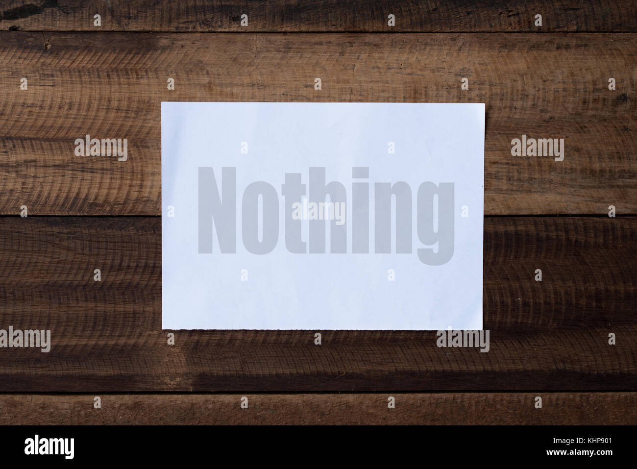 nothing word on paper.piece of paper written 'nothing' on a wooden table background Stock Photo