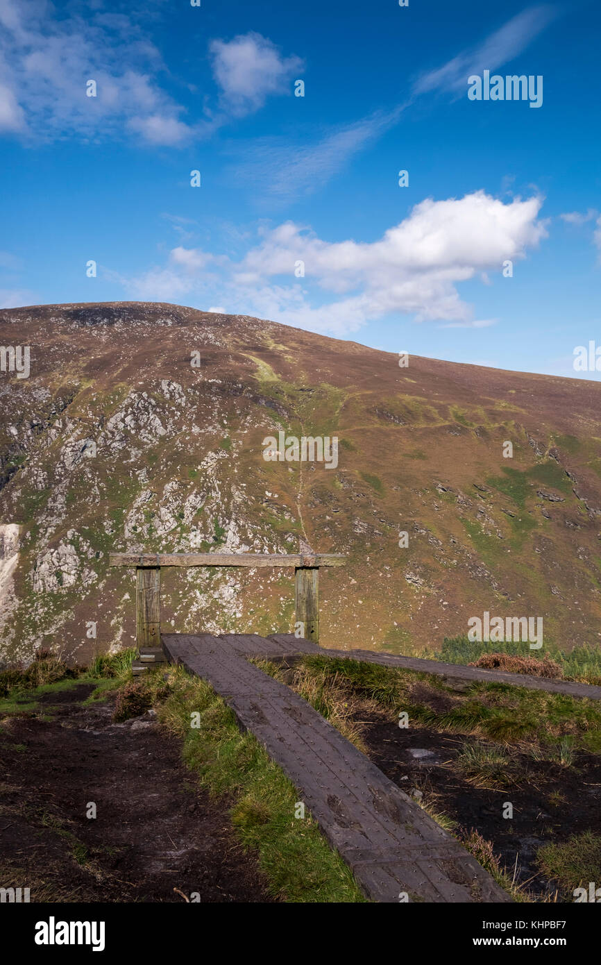 Barrier built from railway sleepers at the cliff edge on the Spinc overlooking Glendalough, Wicklow mountains, Ireland Stock Photo