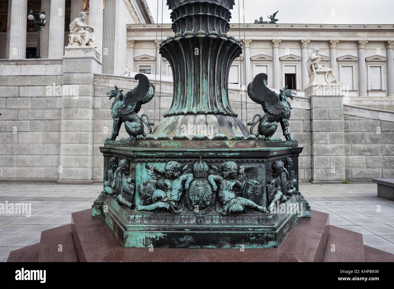Griffins and herubs sculptures at the ornate bottom of a mast in front of Austrian Parliament Building in Vienna city, Austria Stock Photo