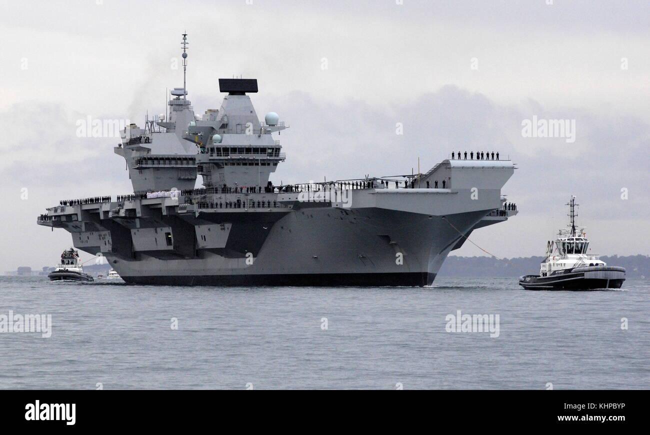 AJAXNETPHOTO. 16TH AUGUST, 2017. PORTSMOUTH, ENGLAND. - ROYAL NAVY'S BIGGEST WARSHIP SAILS INTO HOME PORT - HMS QUEEN ELIZABTH, THE FIRST OF TWO 65,000 TONNE, 900 FT LONG, STATE-OF-THE-ART AIRCRAFT CARRIERS SAILED INTO PORTSMOUTH NAVAL BASE IN THE EARLY HOURS OF THIS MORNING, GENTLY PUSHED AND SHOVED BY SIX TUGS INTO HER NEW BERTH ON PRINCESS ROYAL JETTY. THE £3BN CARRIER, THE LARGEST WARSHIP EVER BUILT FOR THE ROYAL NAVY, ARRIVED AT ARRIVED AT HER HOME PORT TWO DAYS AHEAD OF HER ORIGINAL SCHEDULE.  PHOTO: JONATHAN EASTLAND/AJAX  REF: D171608 6781 Stock Photo