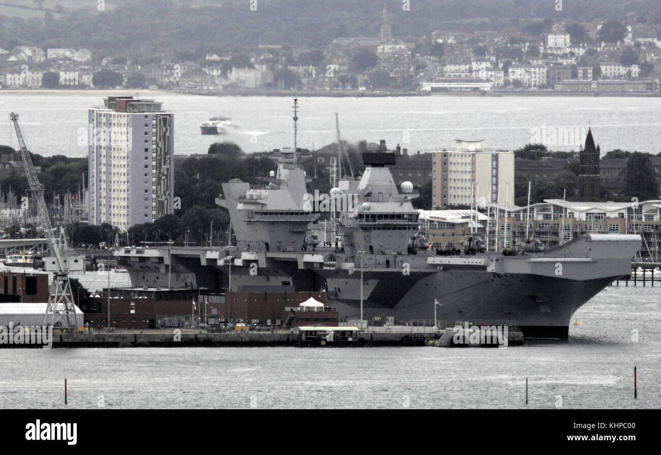 AJAXNETPHOTO. 16TH AUGUST, 2017. PORTSMOUTH, ENGLAND. - ROYAL NAVY'S BIGGEST WARSHIP SAILS INTO HOME PORT - HMS QUEEN ELIZABTH, THE FIRST OF TWO 65,000 TONNE, 900 FT LONG, STATE-OF-THE-ART AIRCRAFT CARRIERS SAILED INTO PORTSMOUTH NAVAL BASE IN THE EARLY HOURS OF THIS MORNING, GENTLY PUSHED AND SHOVED BY SIX TUGS INTO HER NEW BERTH ON PRINCESS ROYAL JETTY. THE £3BN CARRIER, THE LARGEST WARSHIP EVER BUILT FOR THE ROYAL NAVY, ARRIVED AT ARRIVED AT HER HOME PORT TWO DAYS AHEAD OF HER ORIGINAL SCHEDULE.  PHOTO: JONATHAN EASTLAND/AJAX  REF: D171608 6801 Stock Photo