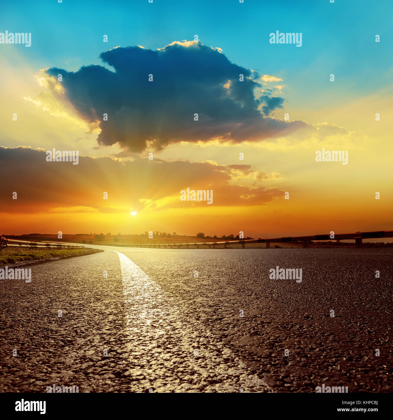 dark clouds over asphalt road on sunset Stock Photo - Alamy
