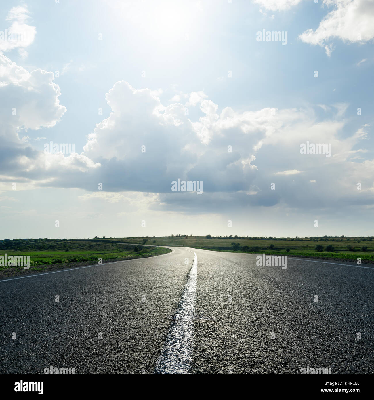 sun in cloudy sky over asphalt road Stock Photo - Alamy