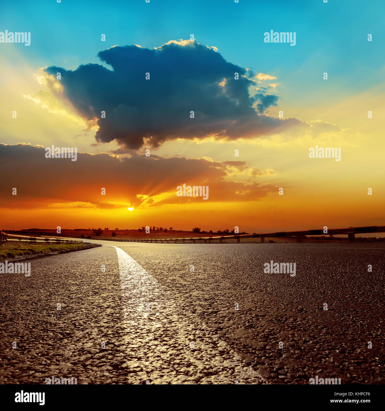 dramatic sunset over asphalt road closeup Stock Photo - Alamy