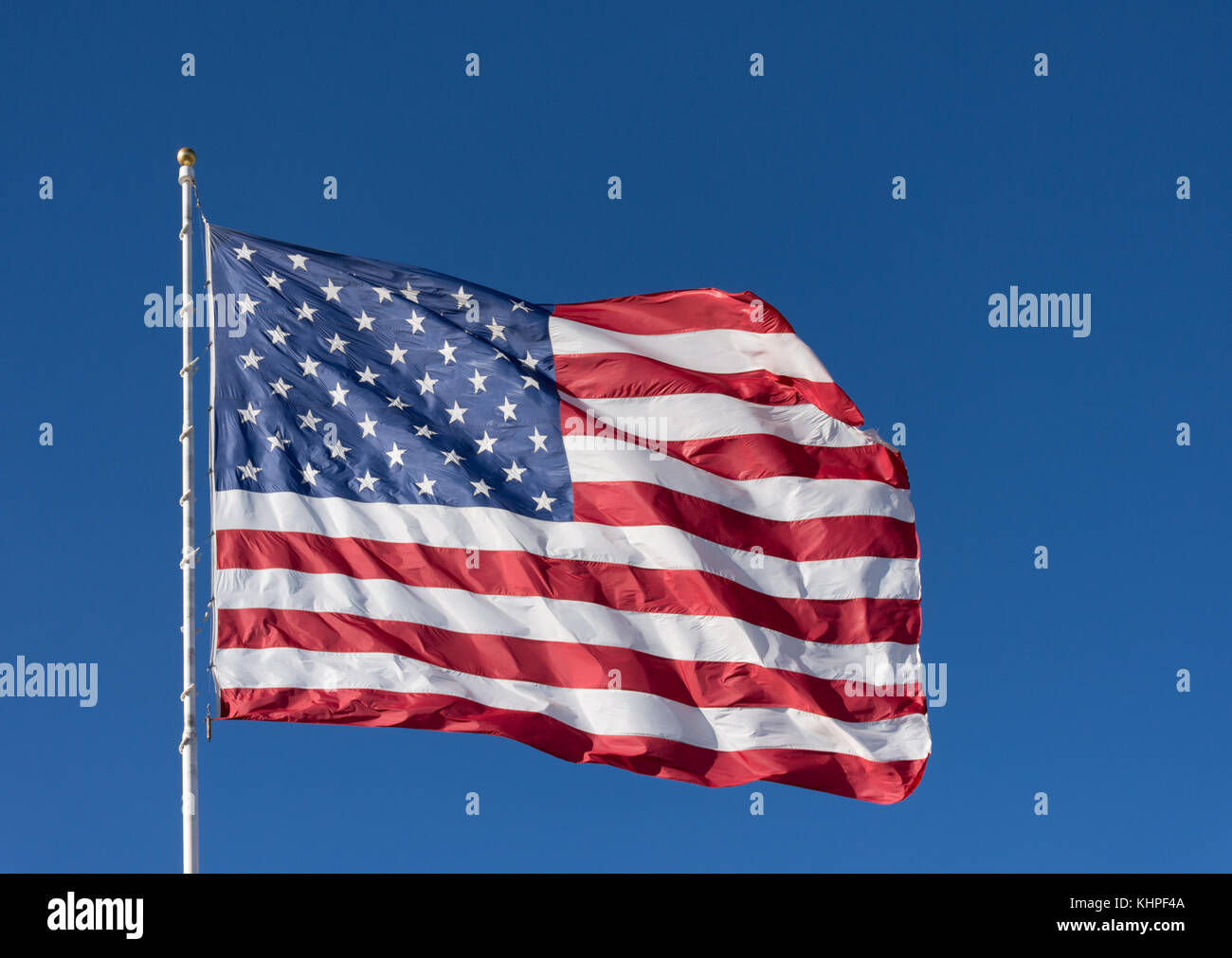 A red, white and blue American flag with stars and stripes unfurled in ...