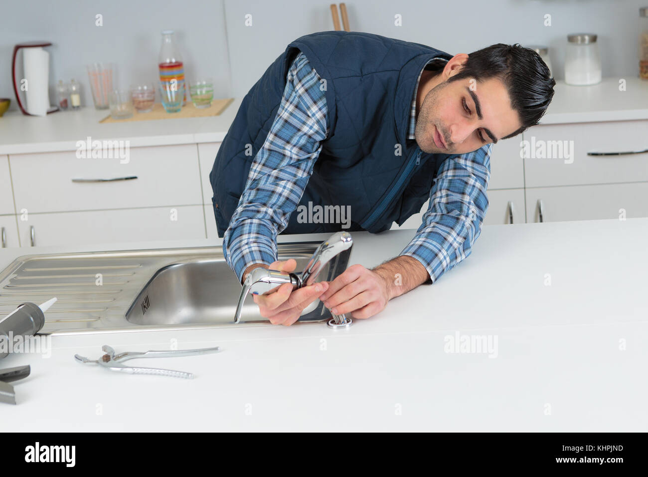 plumber fixing tap on sink Stock Photo Alamy