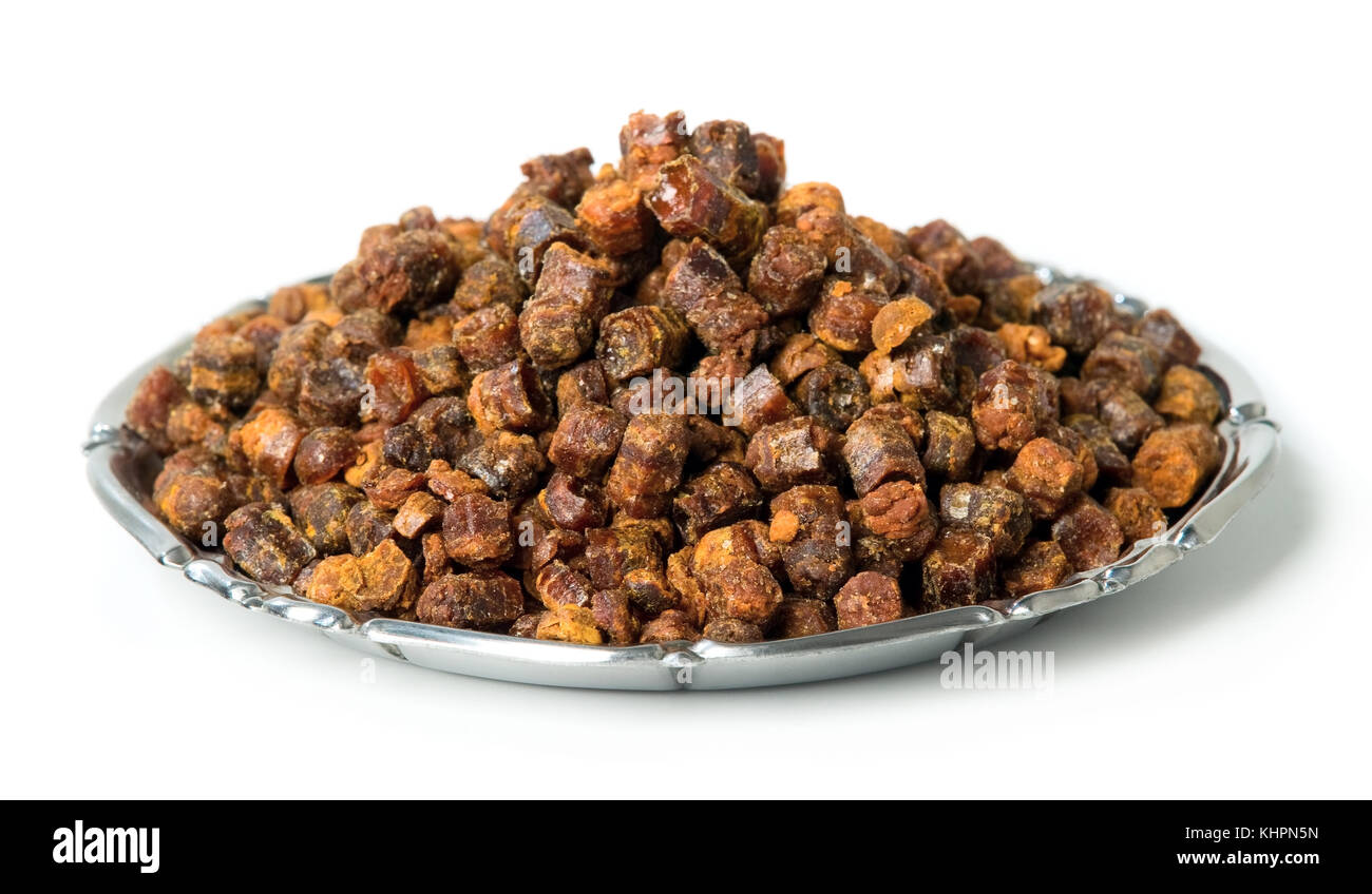 Propolis granules inside plate on background, bee product Stock Photo